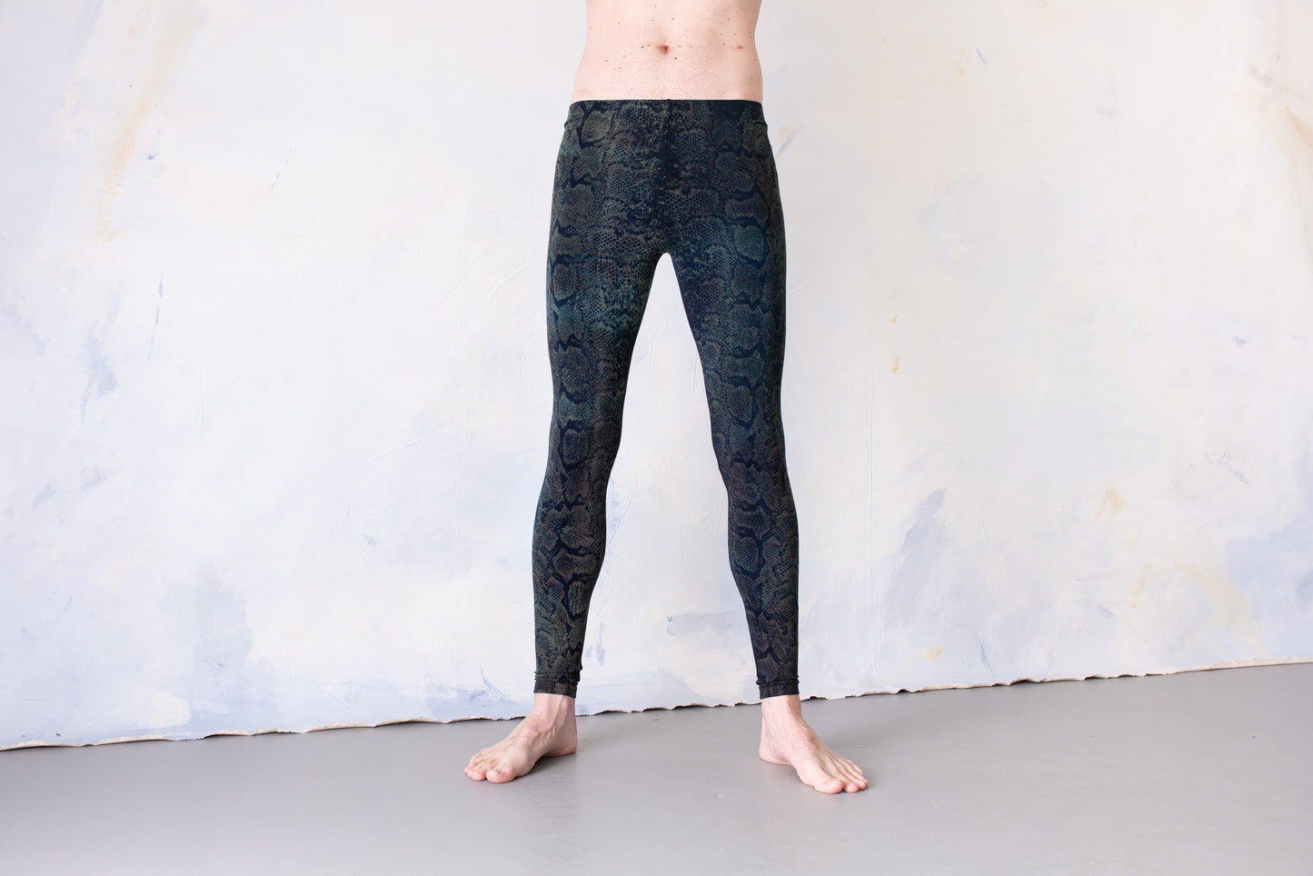Mann trägt Unisex Viskose Batik Leggings mit Schlangenmuster, Animal Print blau-grün – Yoga, Psytrance & Alternative Fashion