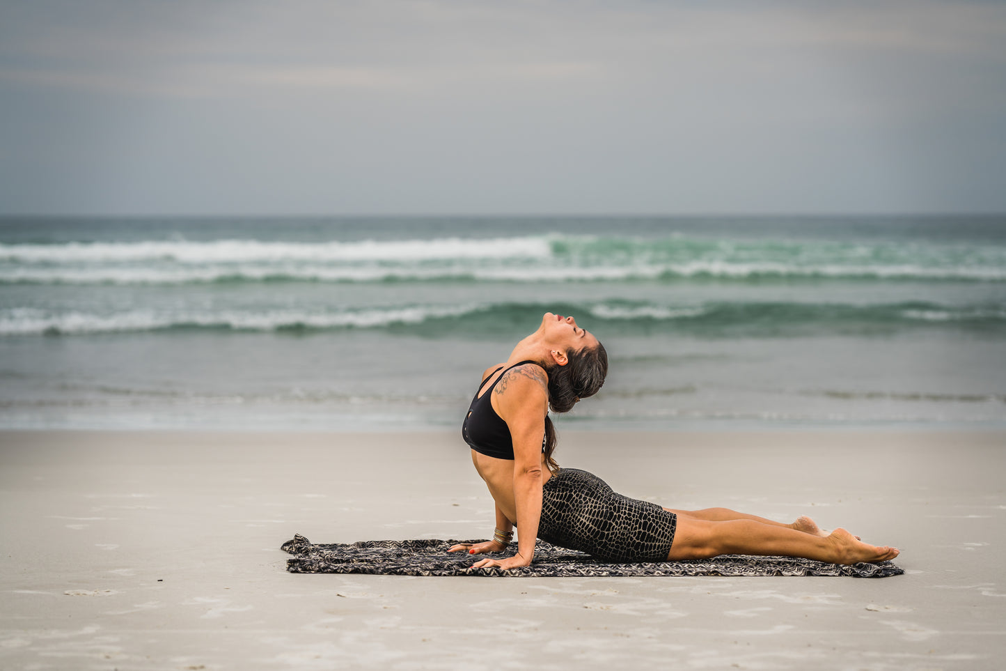 Yoga am Strand: Frau trägt Workout Shorts mit Alligatormuster Batik – abstrakter Print, Alternative Mode, Psytrance, Punk