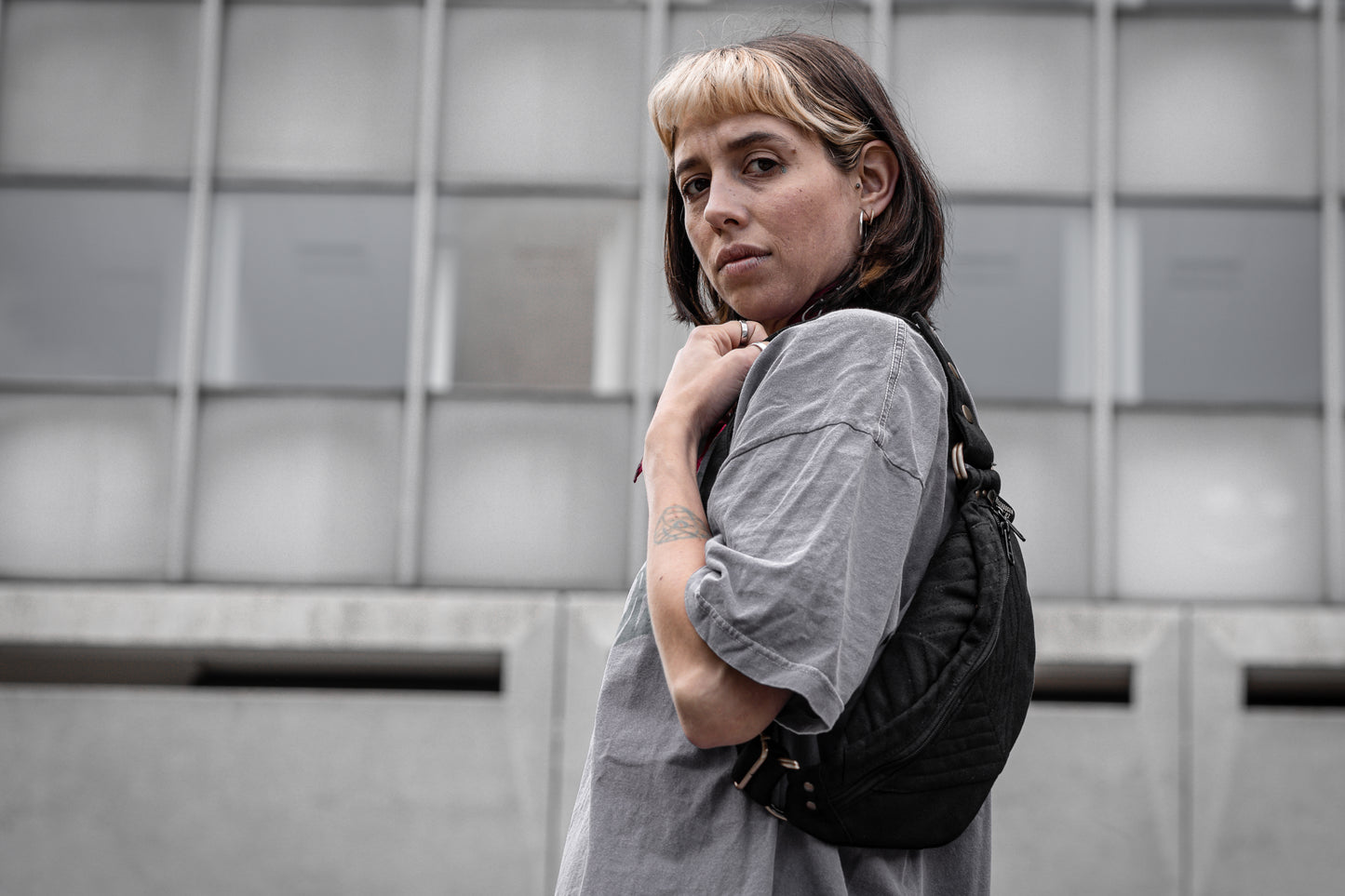 Crossbody-Tasche aus fester Baumwolle mit Nahtstruktur in schwarz, getragen als Shoulder Bag an alternativem Model.