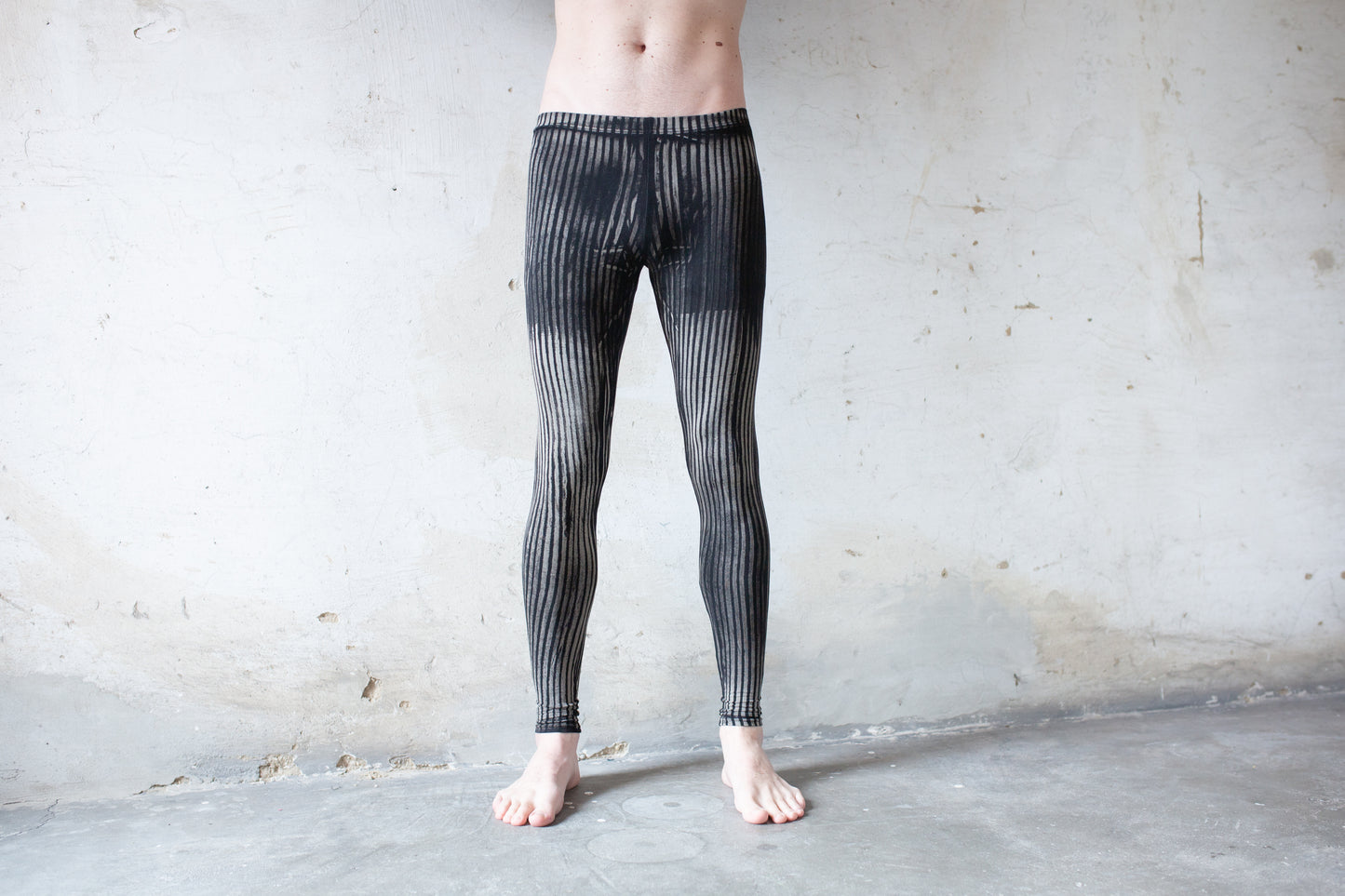 Mann trägt Unisex Viskose Batik Leggings mit Streifenmuster schwarz-beige-grau – Yoga, Psytrance & Alternative Fashion