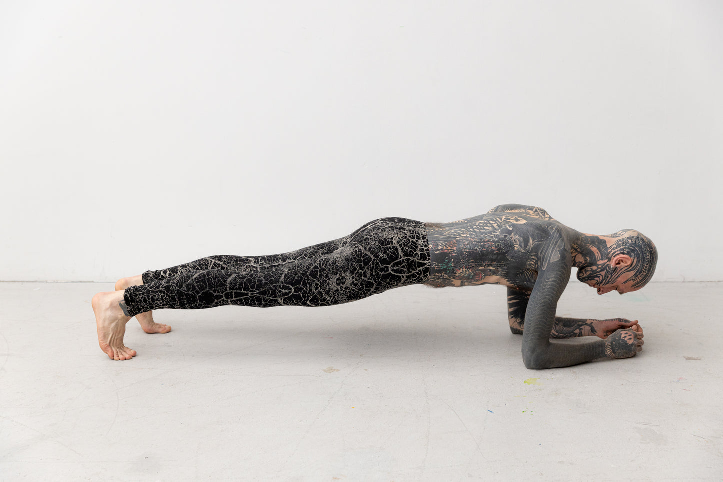 Mann beim Workout trägt Unisex Yoga Leggings mit abstraktem Rissige Erde Print schwarz-grau-beige – Alternative Boho Style