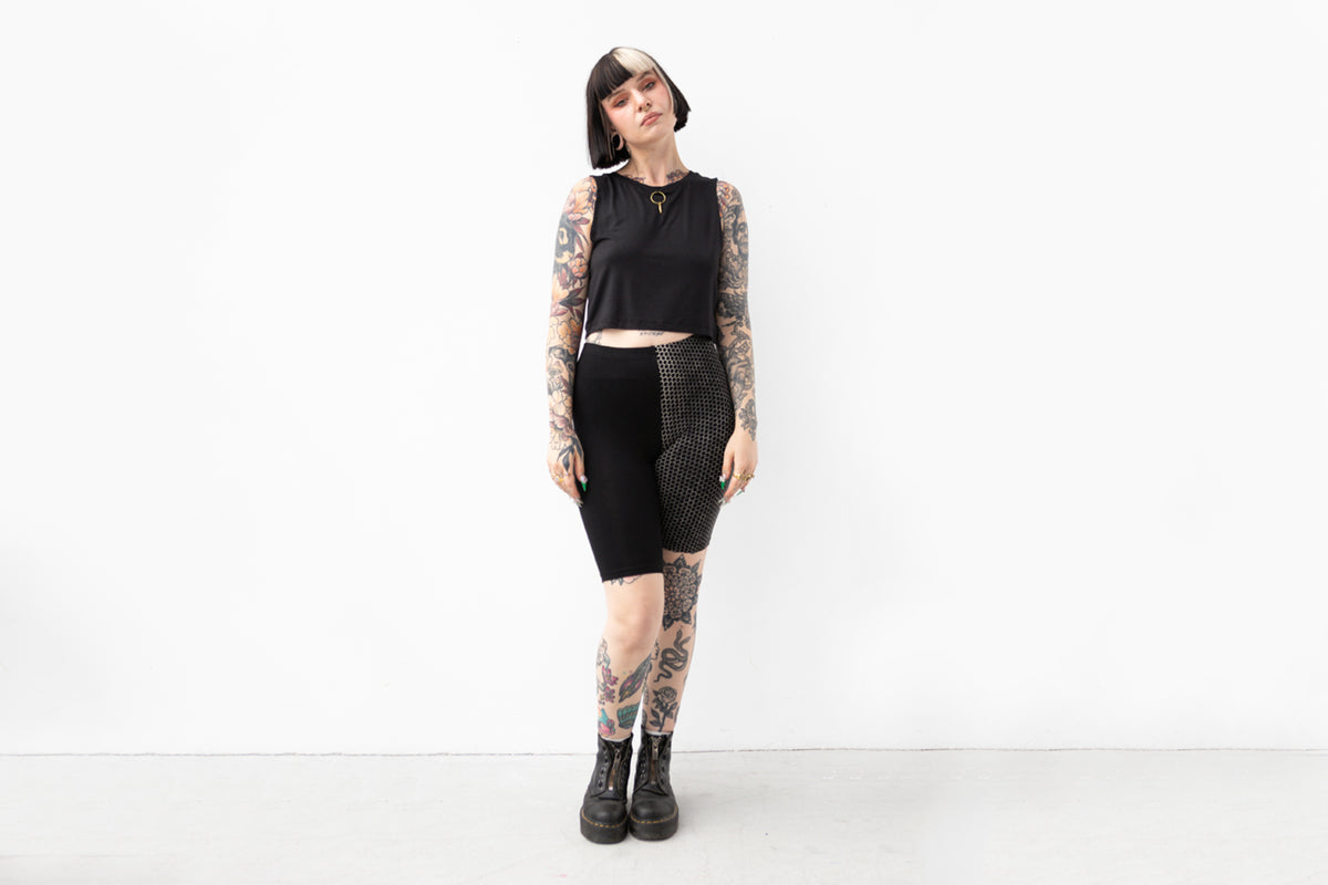 Alternatives Model trägt Mid-Waist Biker Shorts mit asymmetrischem Design für Yoga und Alltag.