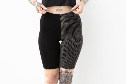 Asymmetrische Radlerhose mit einem bedruckten und einem schwarzen Bein.