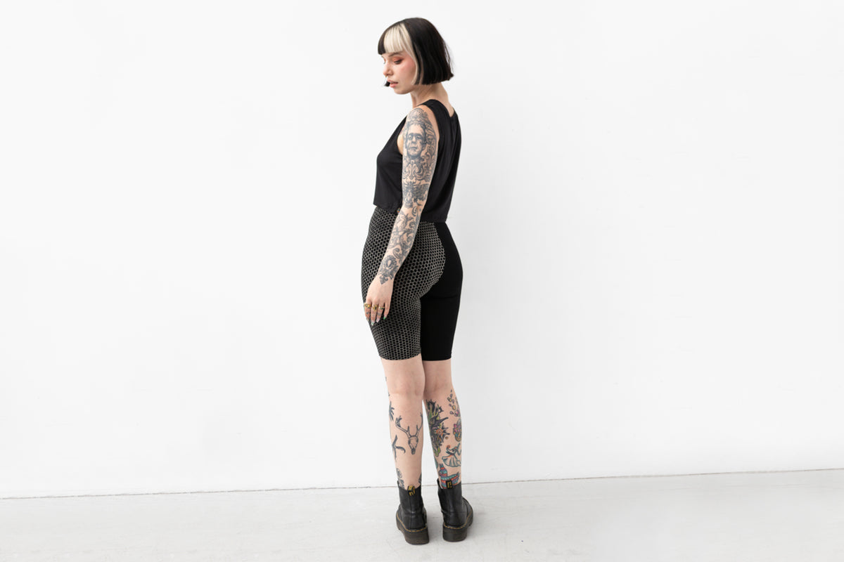 Leggings Shorts mit einfarbig schwarzem und gemustertem Bein, Foto von hinten.