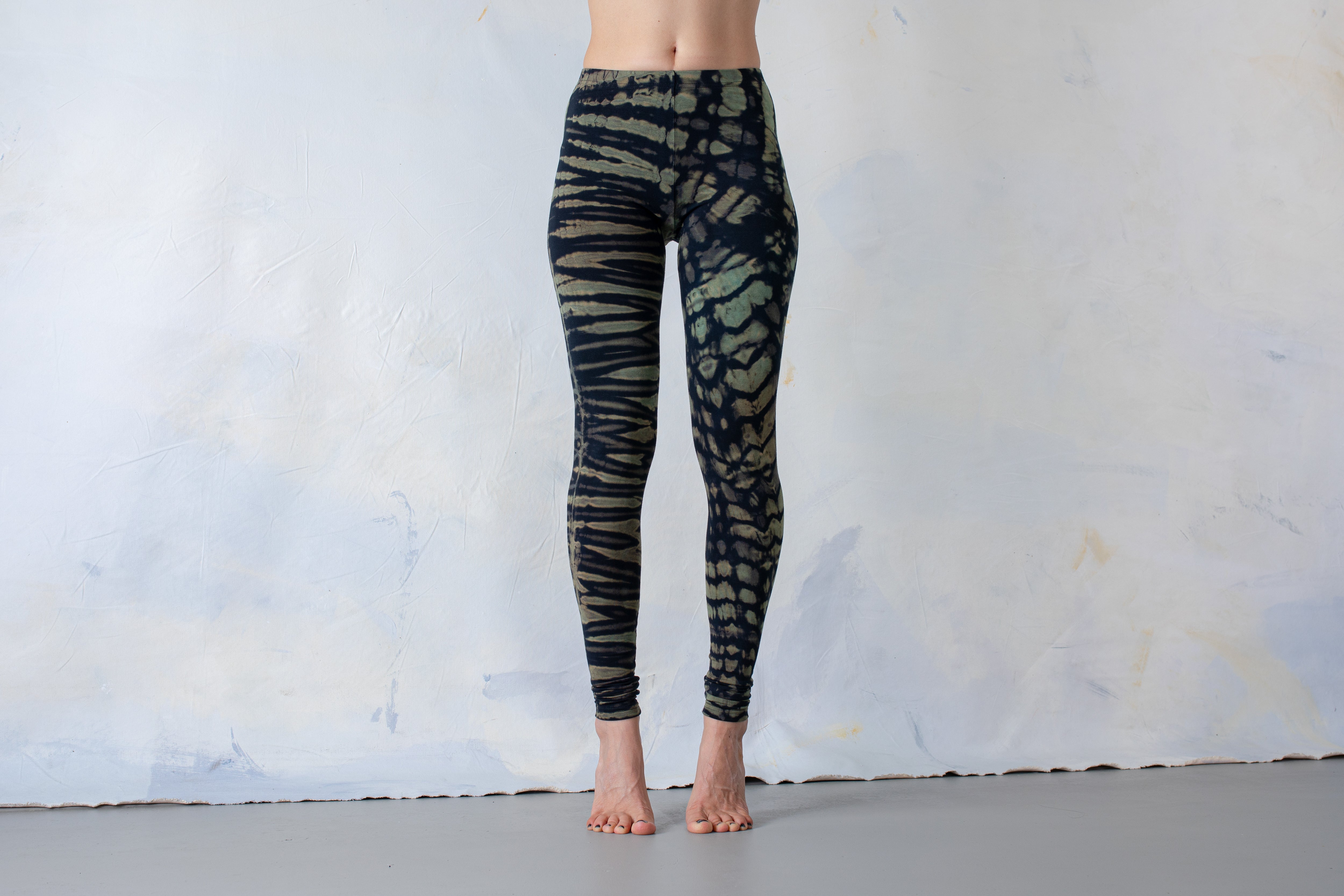 Frau trägt Batik Tie-Dye Leggings mit Animal Print Tigermuster dunkelblau-türkis – Unisex Goa & Festival Look Yoga Wear