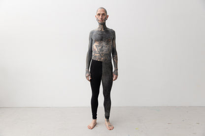 Alternatives Model trägt Leggings mit asymmetrischem Print an einem Bein.