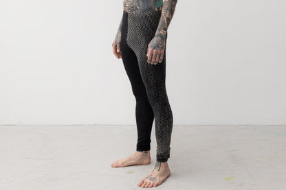 Nahaufnahme von ausgefallener Leggings mit Print an einem Bein in schwarz-beige-grau.