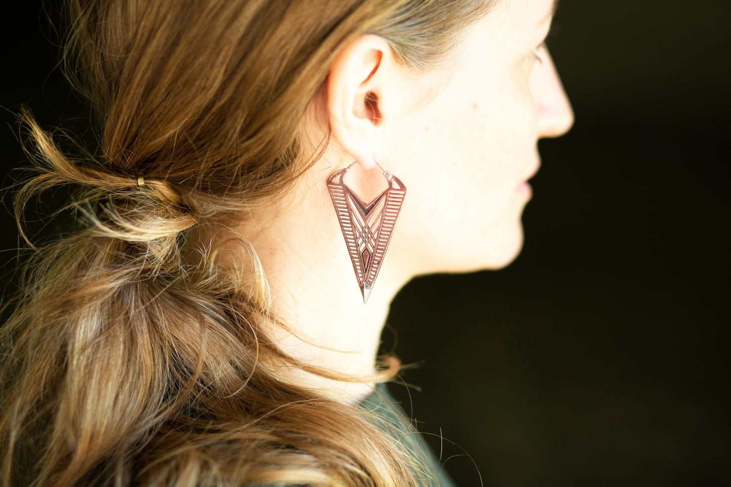 Filigrane Ohrringe aus Kupfer mit geometrischen Linien und silbernen Details für einen auffälligen Look.