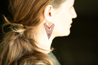 Filigrane Ohrringe aus Kupfer mit geometrischen Linien und silbernen Details für einen auffälligen Look.