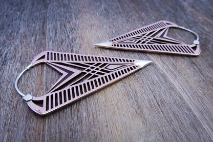 Detailverliebte Hoop Ohrringe aus Kupfer mit geometrischen Ornamenten und silbernen Elementen.