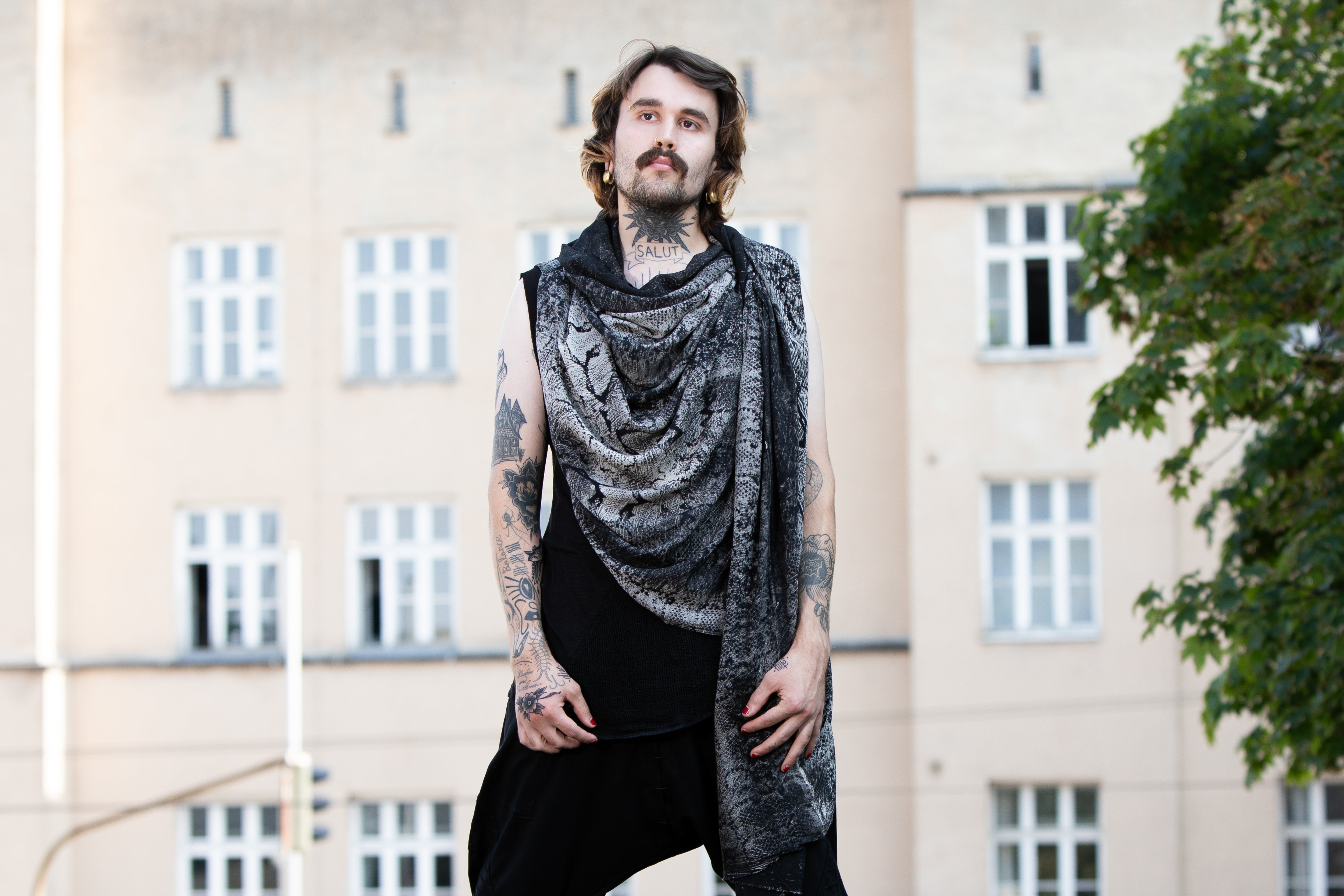 Männliches Model trägt einen schwarzen Viskose-Sarong mit grau-beigem Schlangen-Batikmuster