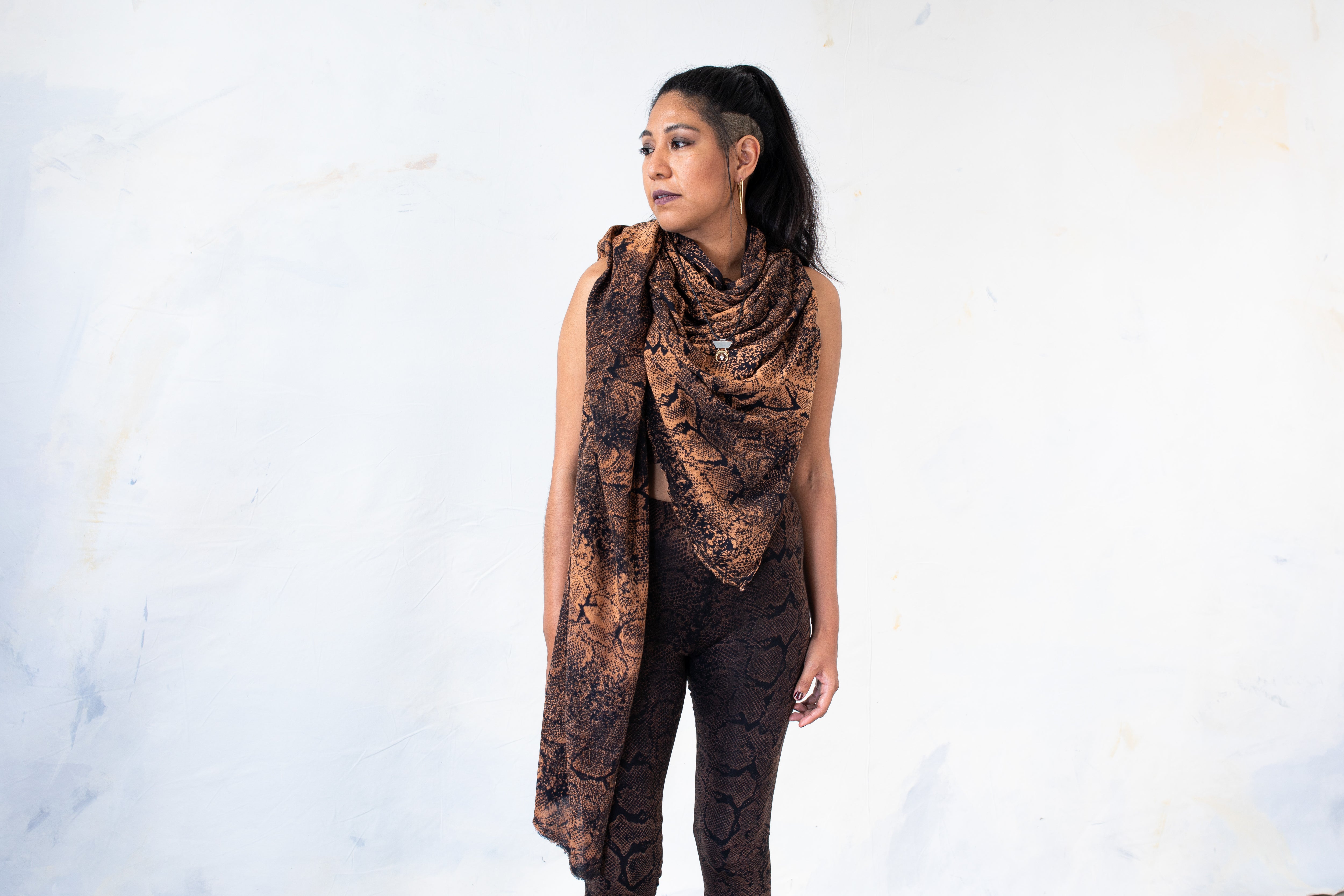 Model trägt einen schwarzen Viskose-Sarong mit apricot-orangem Schlangen-Batikmuster