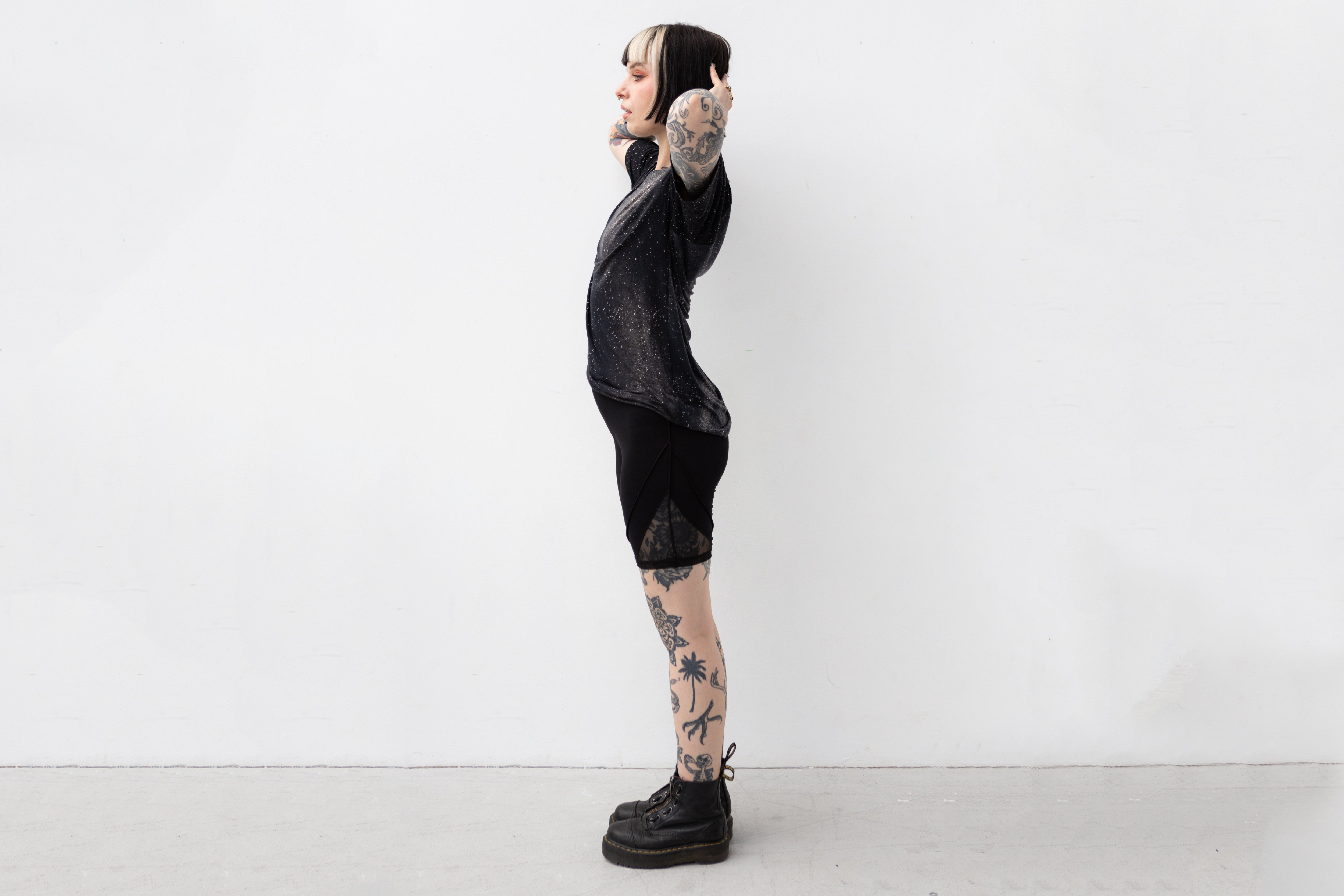 Weiblich gelesenes Model trägt locker geschnittenes unisex T-Shirt mit Universum Motiv