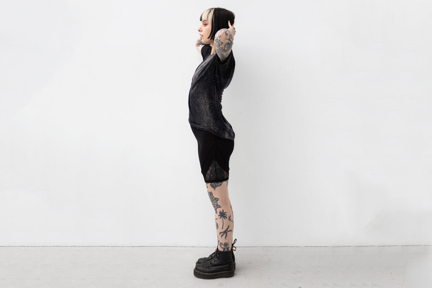 Weiblich gelesenes Model trägt locker geschnittenes unisex T-Shirt mit Universum Motiv