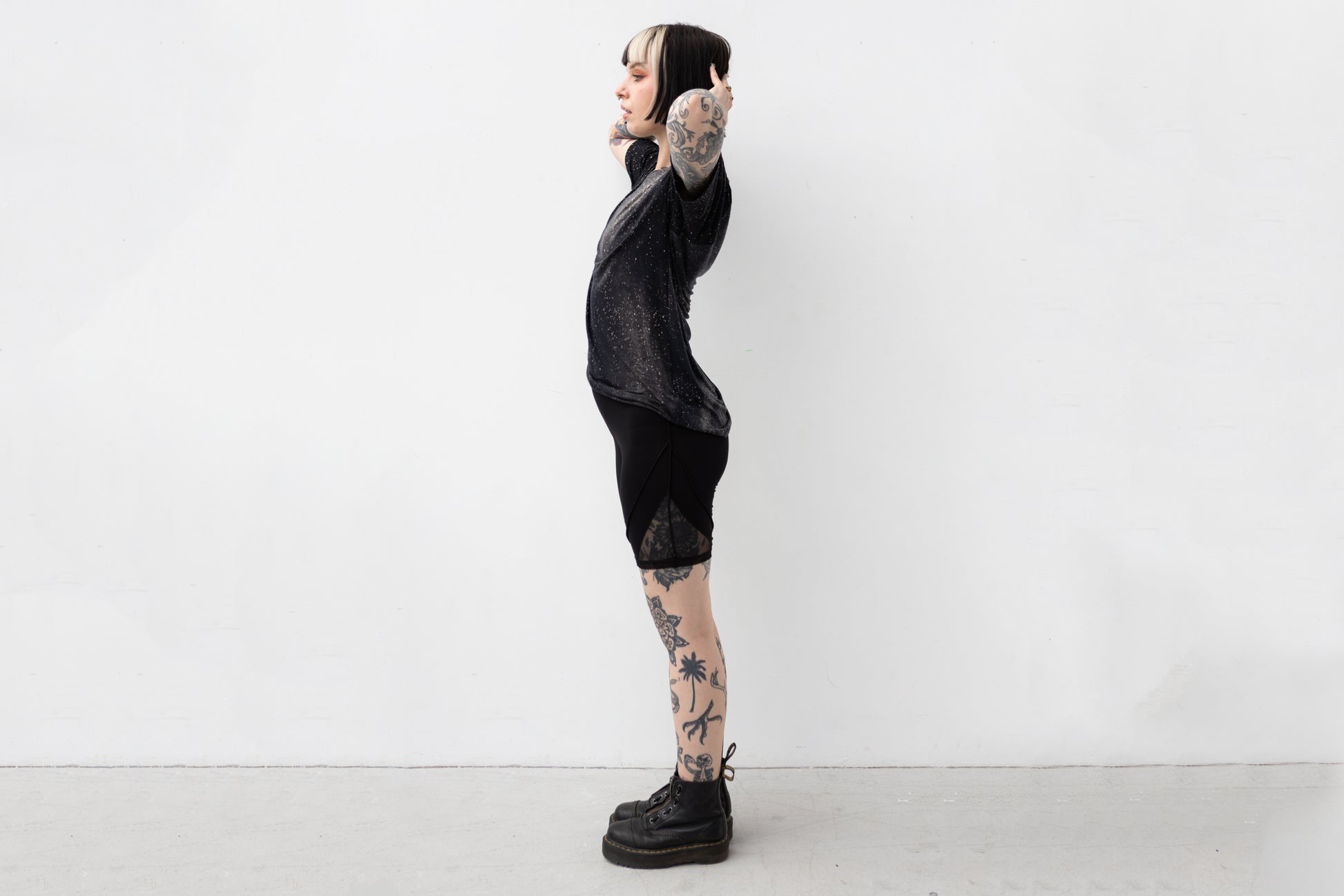 Weiblich gelesenes Model trägt locker geschnittenes unisex T-Shirt mit Universum Motiv