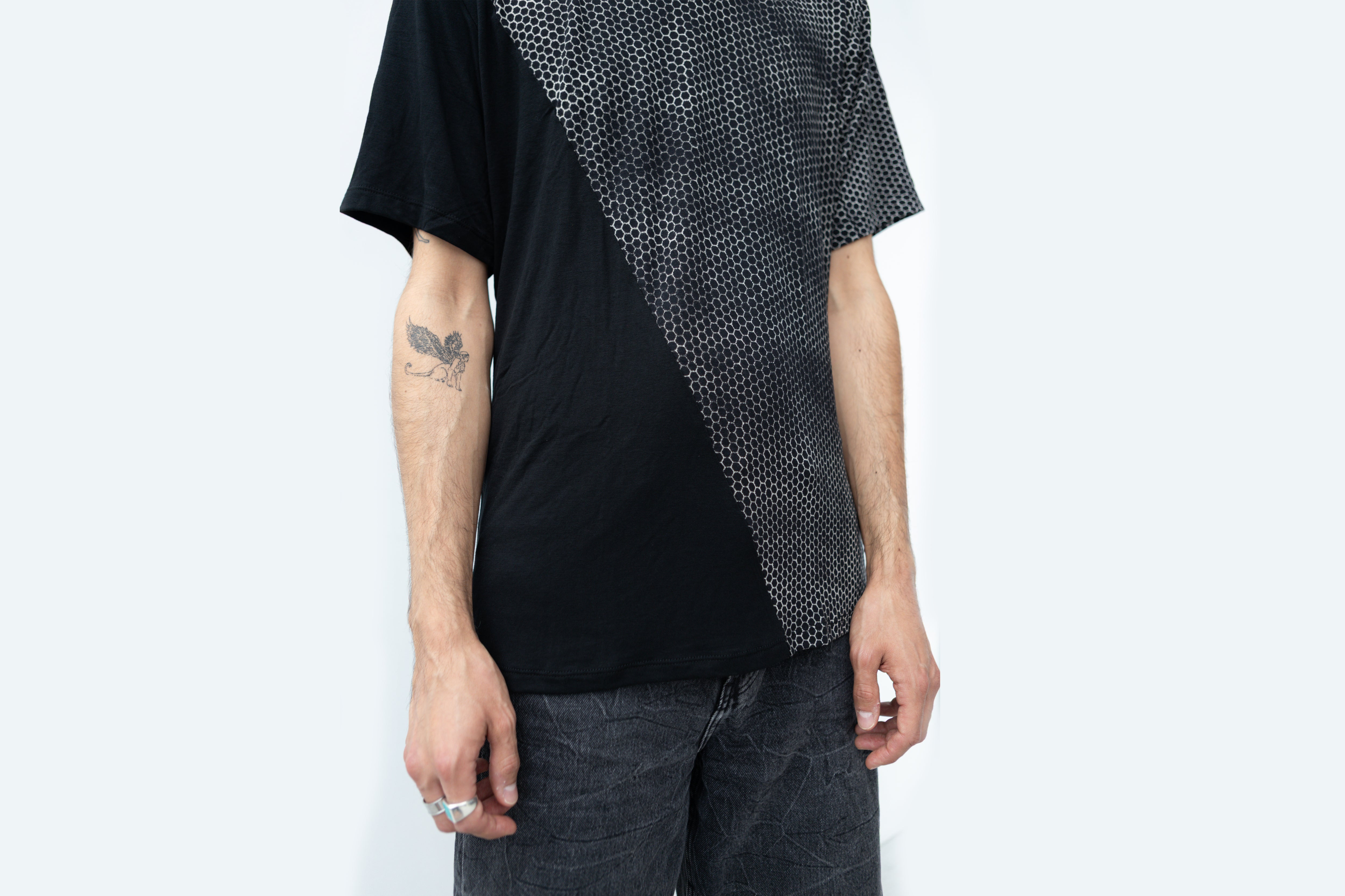 Nahaufnahme unisex T-Shirt mit asymmetrischem Hexagon-Muster in schwarz grau beige.