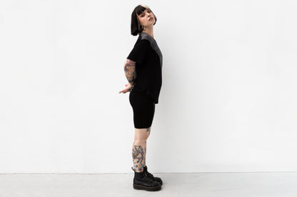 Seitliche Ansicht von schwarzem T-Shirt mit asymmetrischem Druck.
