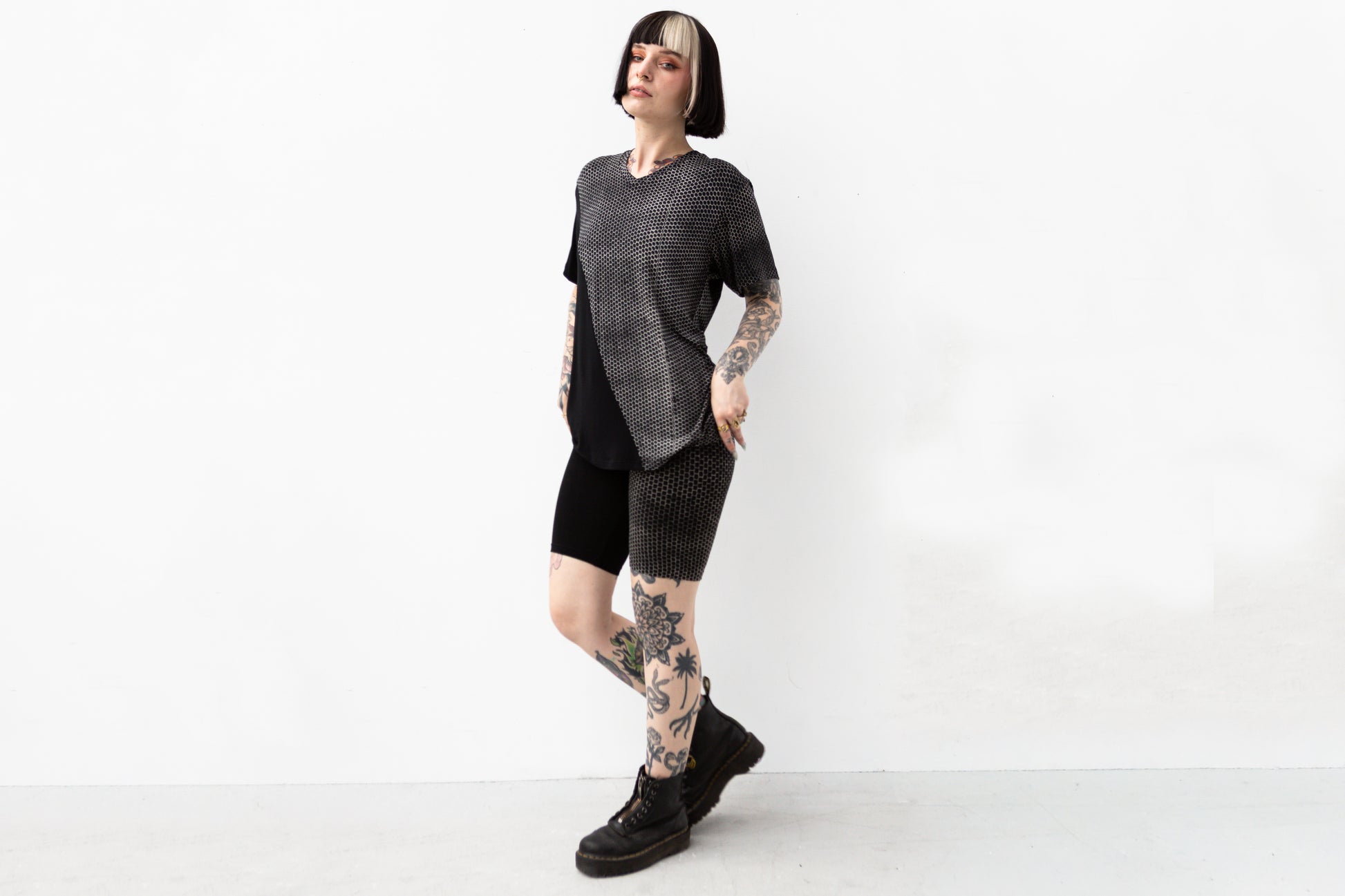 Model trägt locker-geschnittenes Shirt, asymmetrisch bedruckt, im Psytrance-Look.