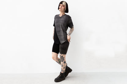 Model trägt locker-geschnittenes Shirt, asymmetrisch bedruckt, im Psytrance-Look.