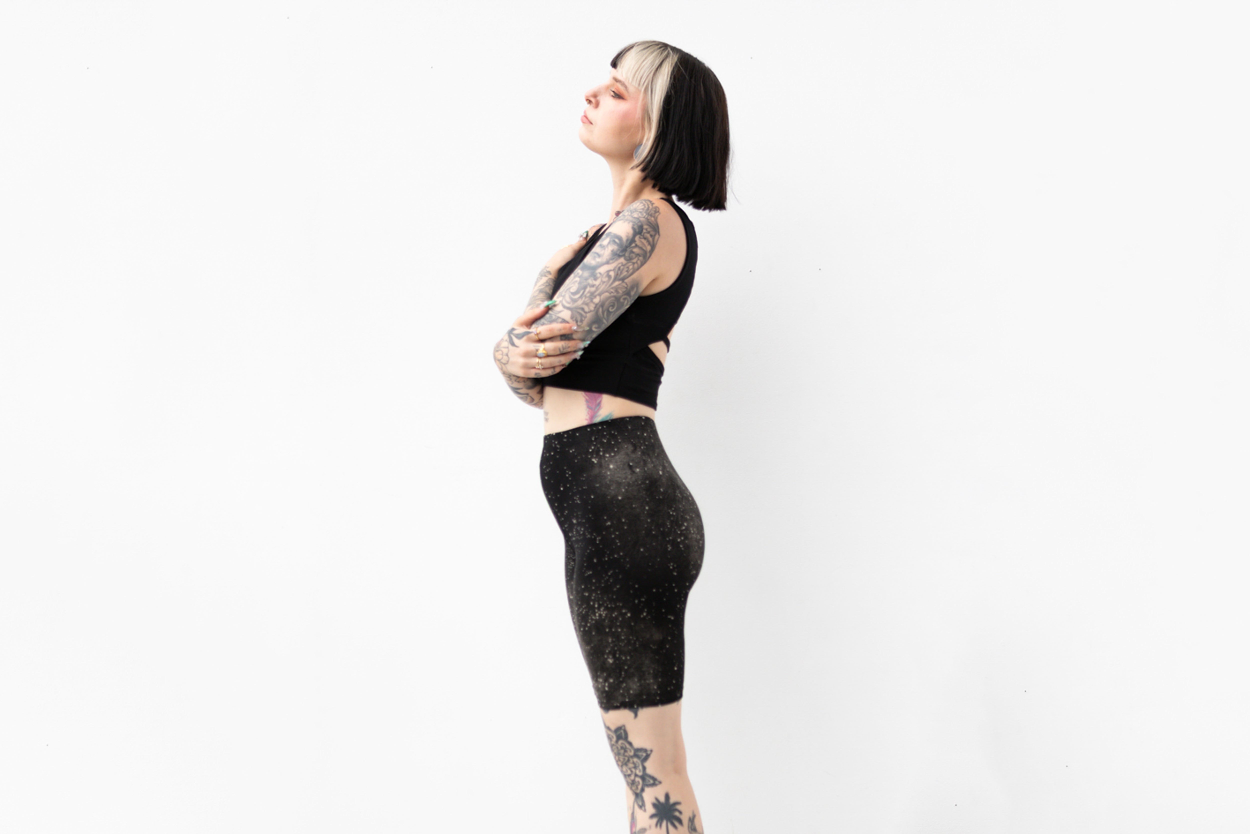 Seitliche Ansicht einer Mid-Waist Radlerhose mit abstraktem Universum-Print.
