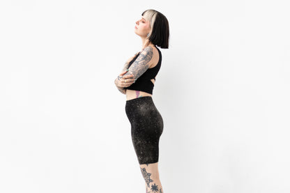 Seitliche Ansicht einer Mid-Waist Radlerhose mit abstraktem Universum-Print.