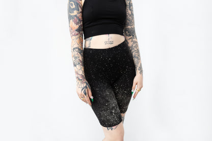 Biker Shorts mit abstraktem Sternenhimmel-Muster in Schwarz mit Grau-Beigem Batik-Siebdruck-Muster, Vorderansicht.