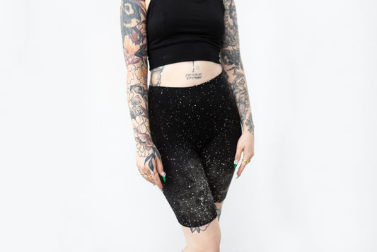 Biker Shorts mit abstraktem Sternenhimmel-Muster in Schwarz mit Grau-Beigem Batik-Siebdruck-Muster, Vorderansicht.