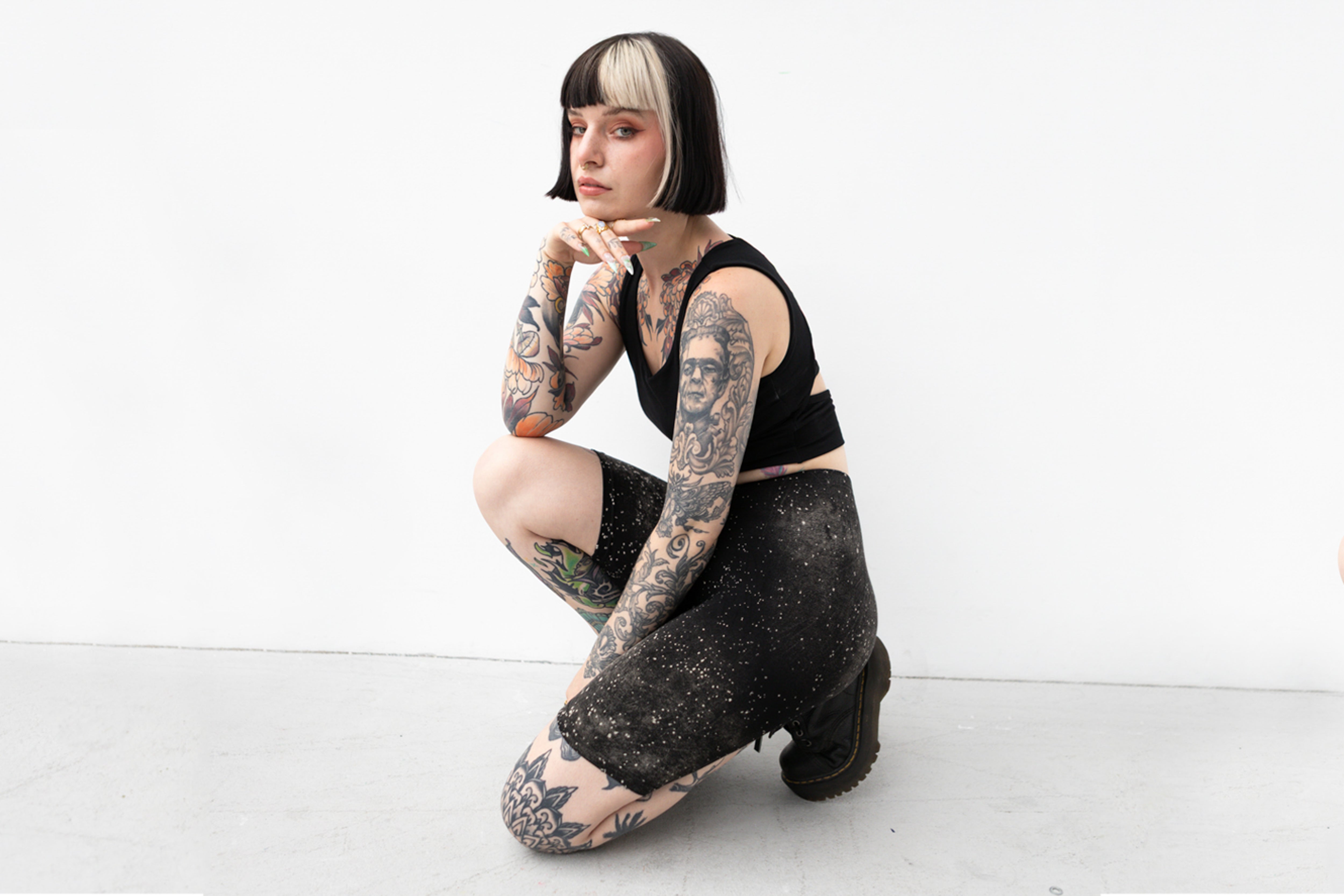 Alternatives Model trägt schwarze Biker Shorts mit künstlerischem Sternenhimmel-Muster.