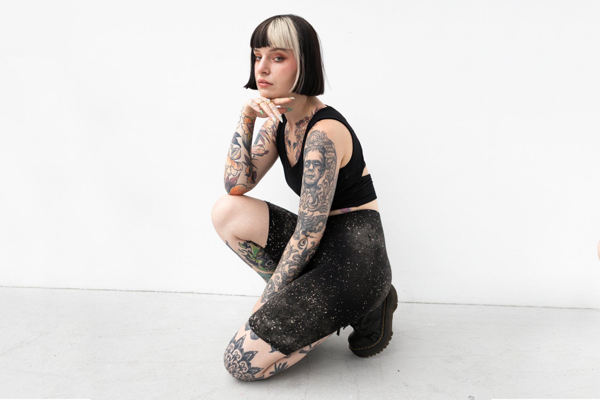 Alternatives Model trägt schwarze Biker Shorts mit künstlerischem Sternenhimmel-Muster.