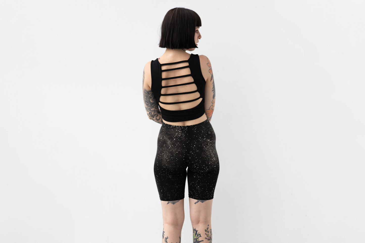 Weiche Yoga Shorts mit abstraktem Galaxie-Print in Grau und Beige auf schwarzem Untergrund, Aufnahme von hinten.