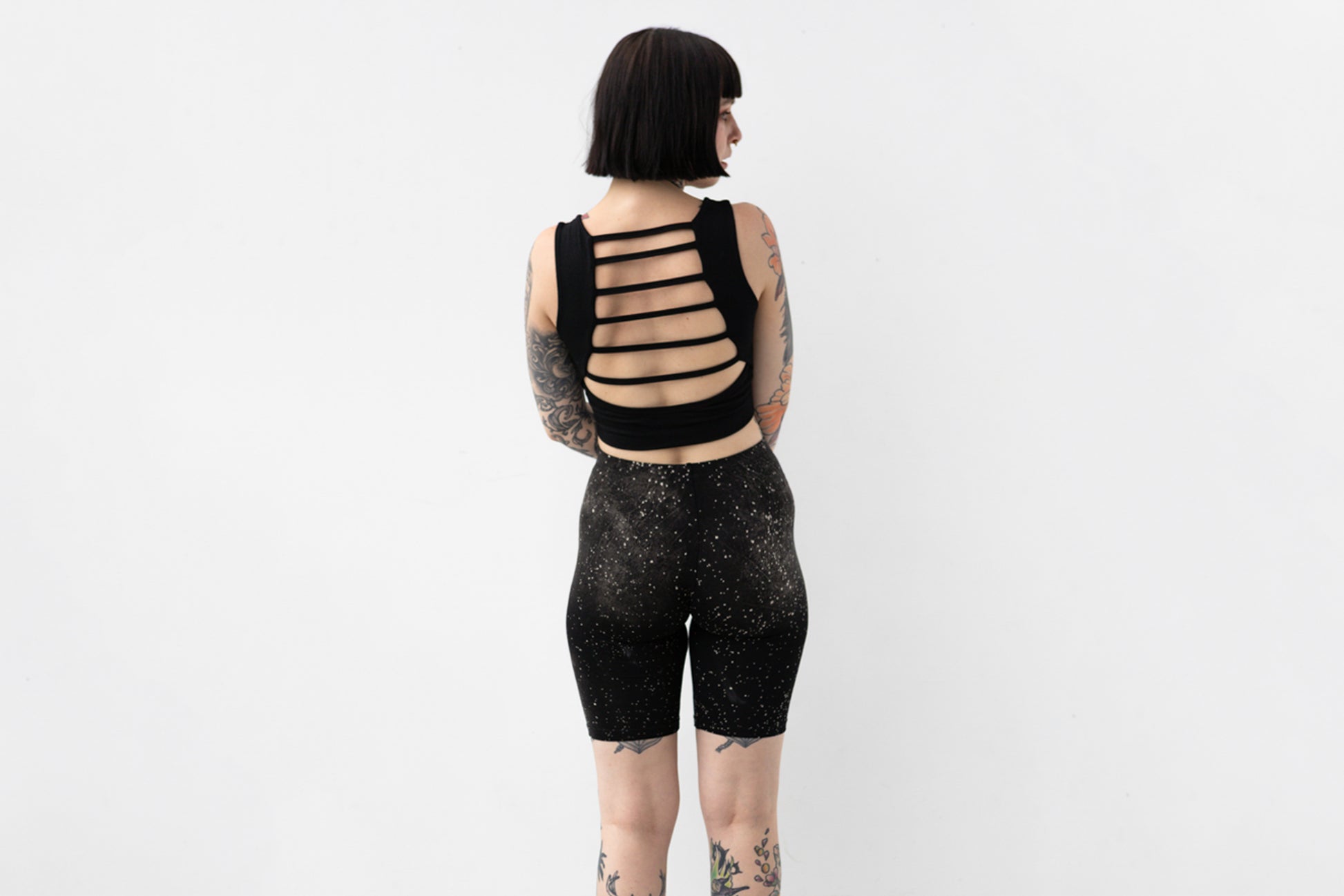 Weiche Yoga Shorts mit abstraktem Galaxie-Print in Grau und Beige auf schwarzem Untergrund, Aufnahme von hinten.