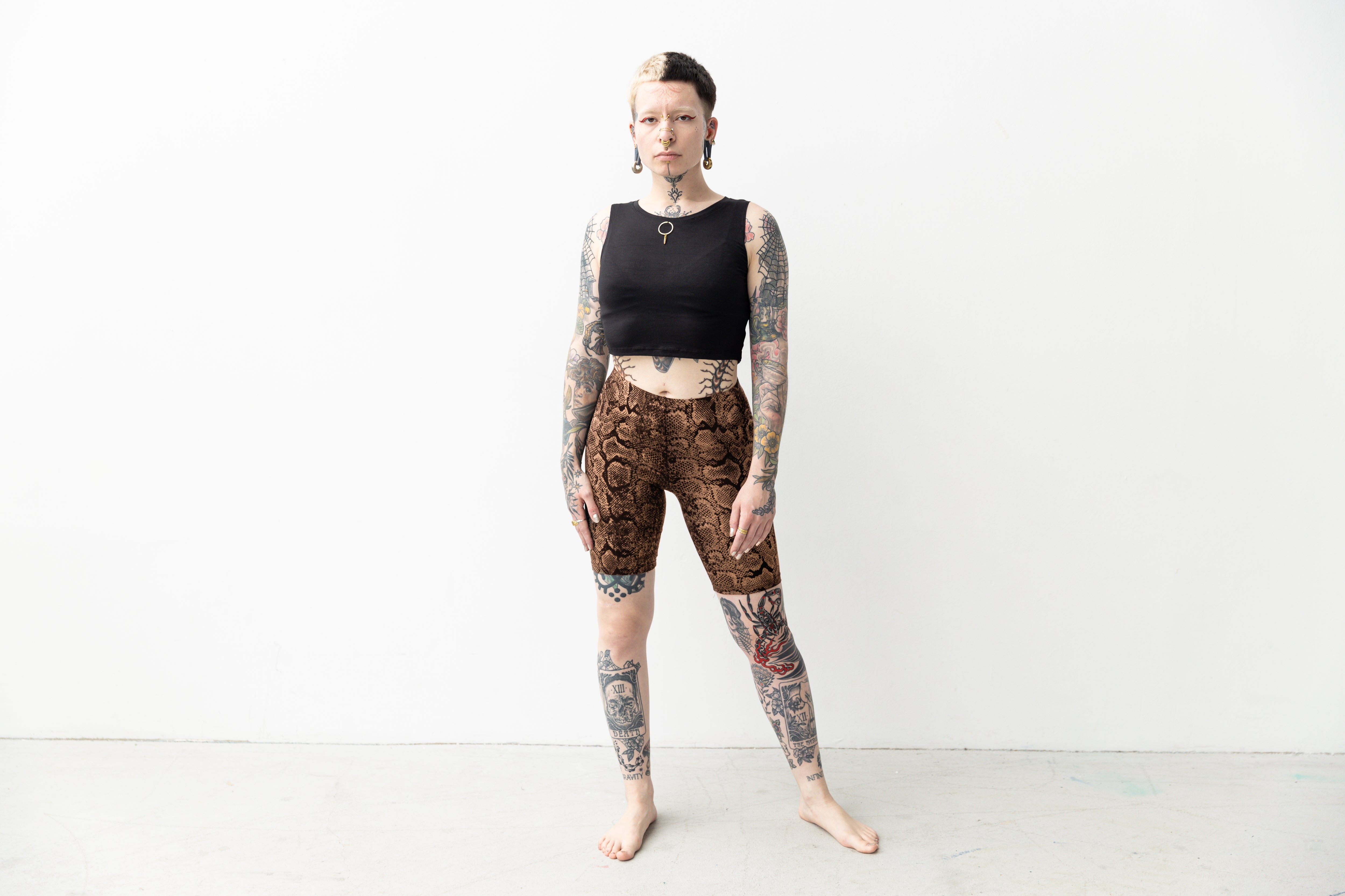 Alternatives Model trägt bequeme Radlerhose mit künstlerischem Farbverlauf von Apricot bis Schwarz.