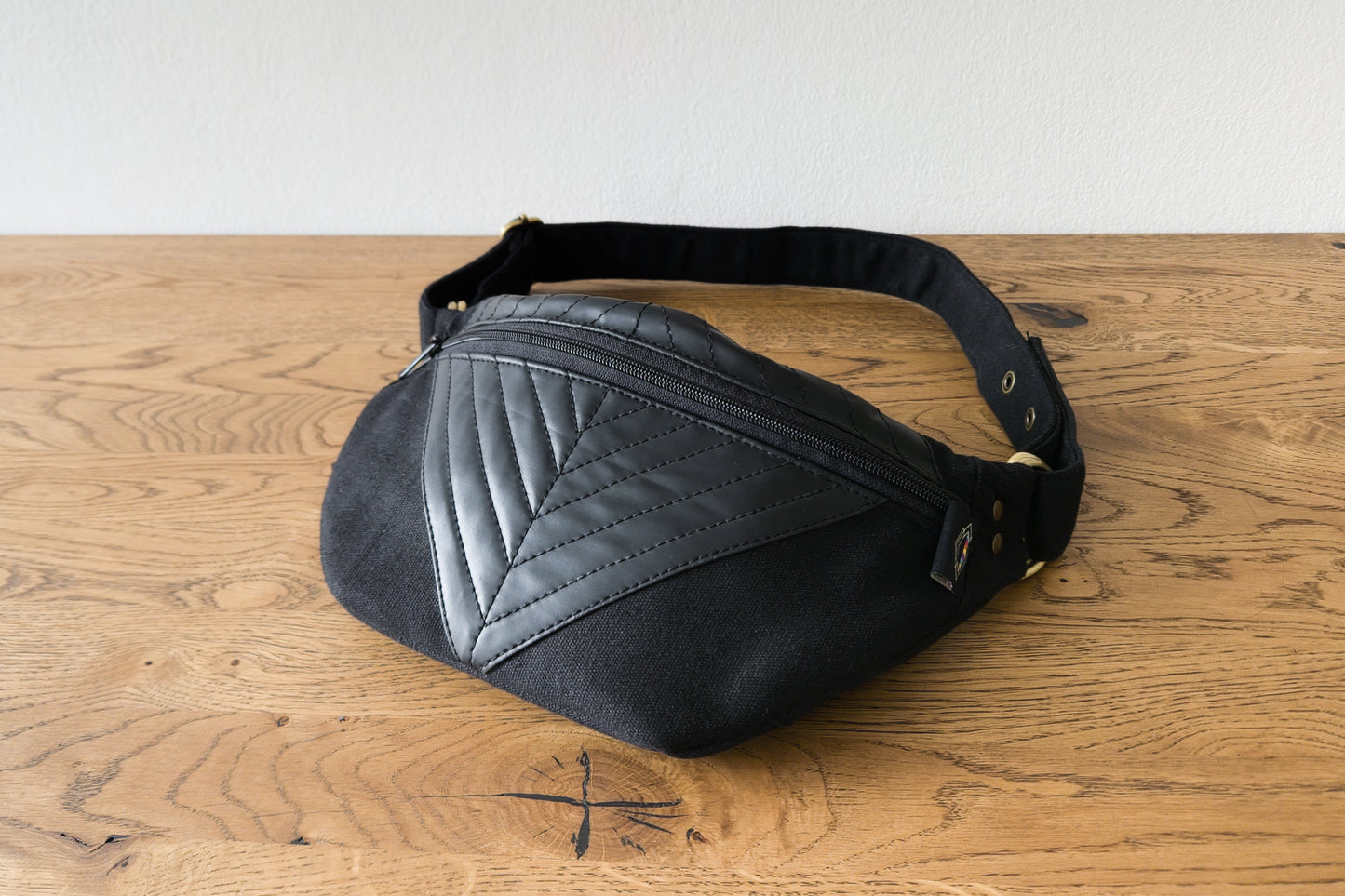 Crossbody-Tasche aus Baumwolle mit Kunstlederapplikation in schwarz, Gesamtansicht liegend, kleine Größenvariante XS-S-M zum Schließen mit Druckknöpfen.