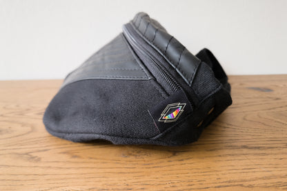 Seitliche Ansicht von Crossbody-Tasche mit Kunstleder und Nahtstruktur.