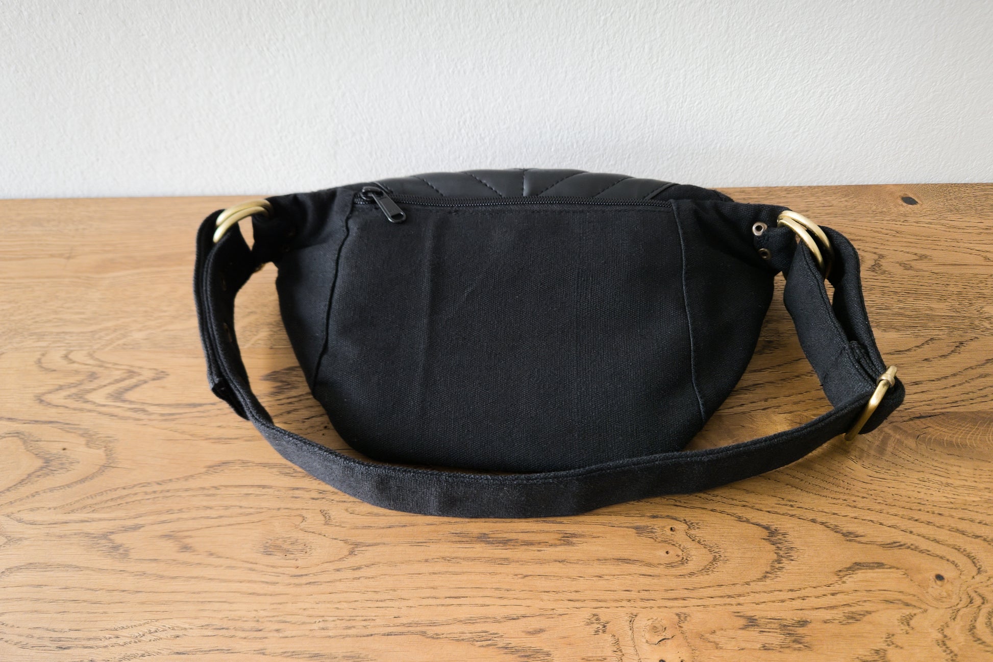 Crossbody-Tasche in schwarz, Rückseite mit Reißverschlussfach.