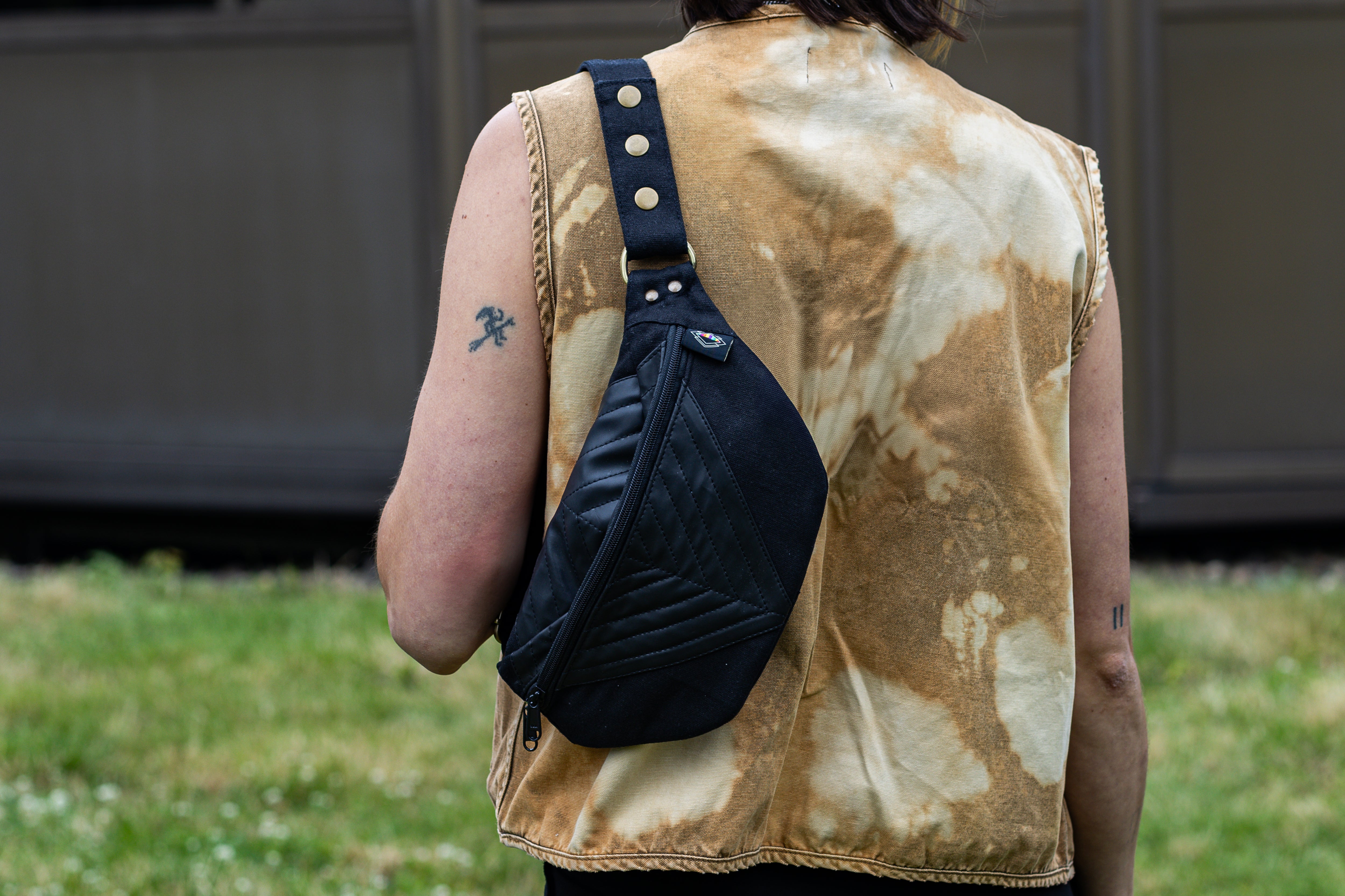 Crossbody-Tasche aus Baumwolle mit Kunstleder und Nahtstruktur in schwarz, getragen als Schultertasche.