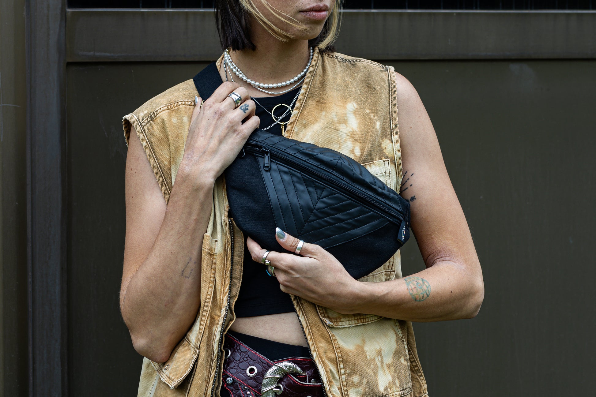 Crossbody-Tasche aus fester Baumwolle mit Nahtstruktur und Kunstleder in schwarz, getragen als Crossbody an alternativem Model.