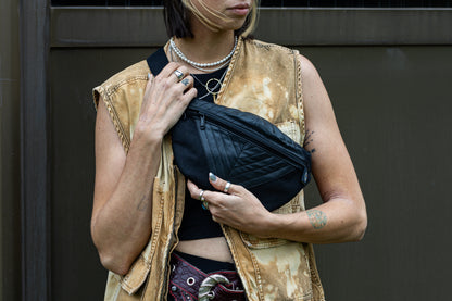 Crossbody-Tasche aus fester Baumwolle mit Nahtstruktur und Kunstleder in schwarz, getragen als Crossbody an alternativem Model.