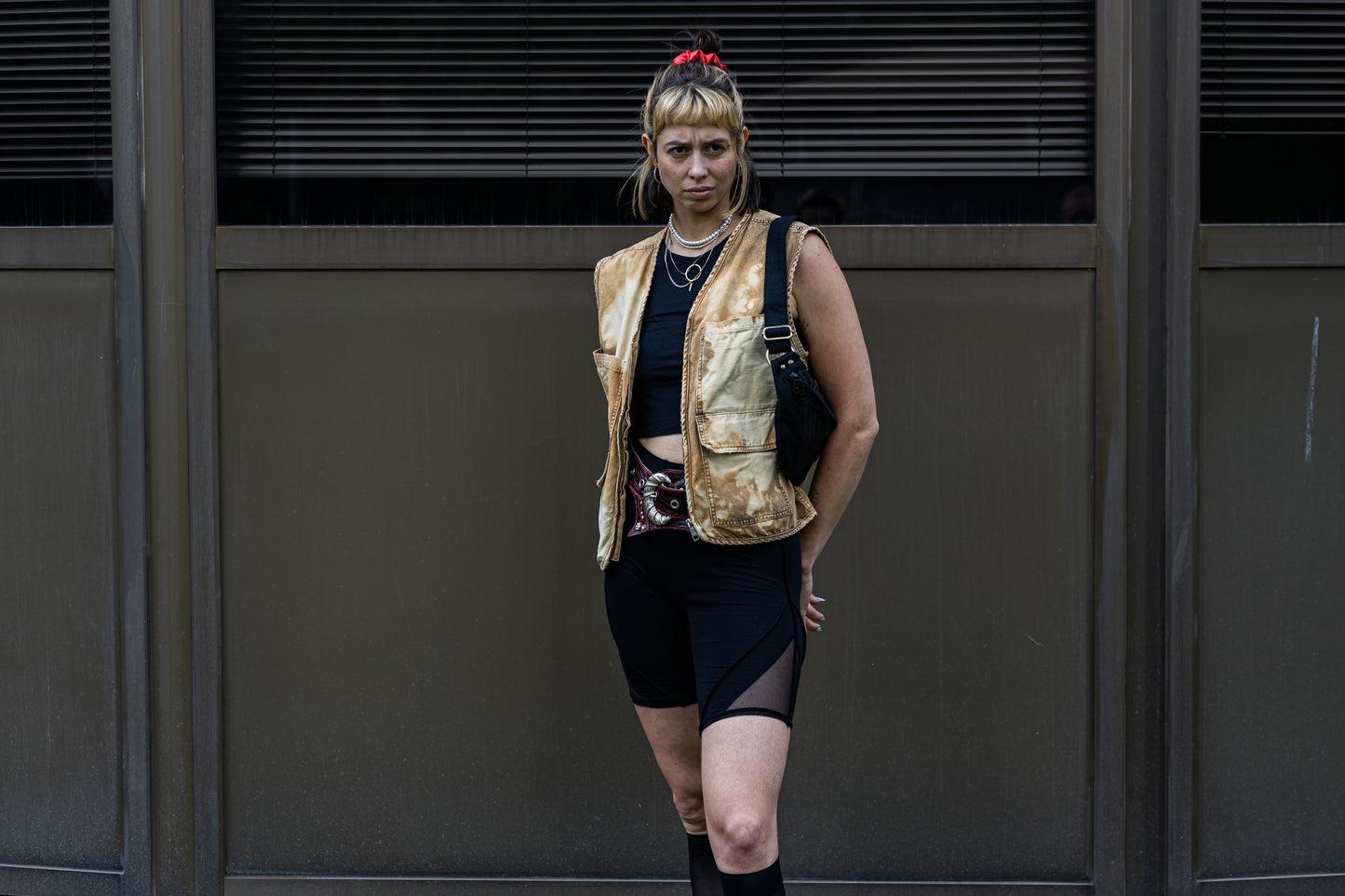 Alternatives Model mit Rave-Outfit trägt schwarze Crossbody-Tasche aus Baumwolle über die Schulter gehängt.