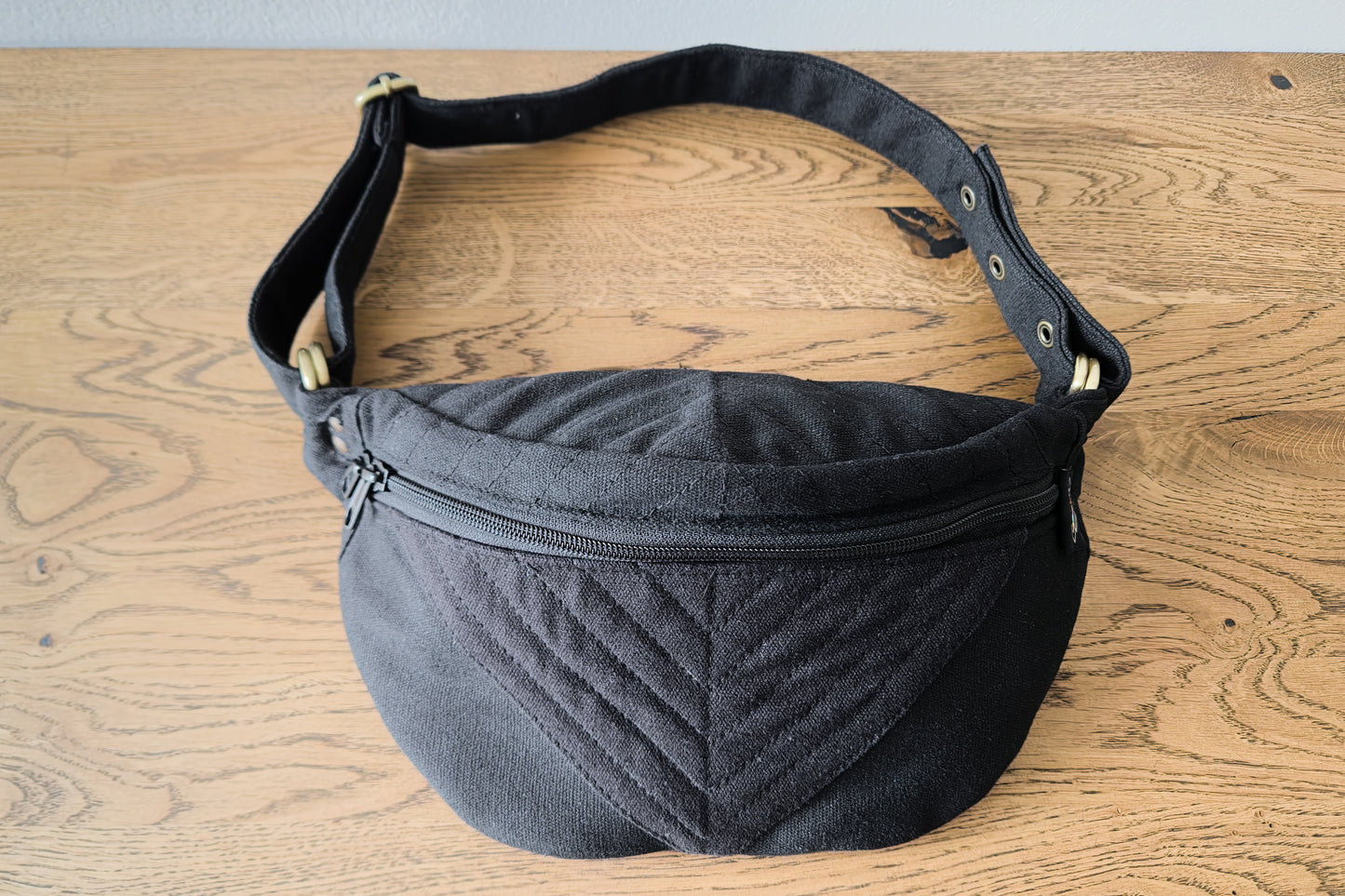 Crossbody-Tasche aus Baumwolle mit Nahtstruktur in schwarz, Gesamtansicht liegend, kleine Größenvariante XS-S-M zum Schließen mit Druckknöpfen.