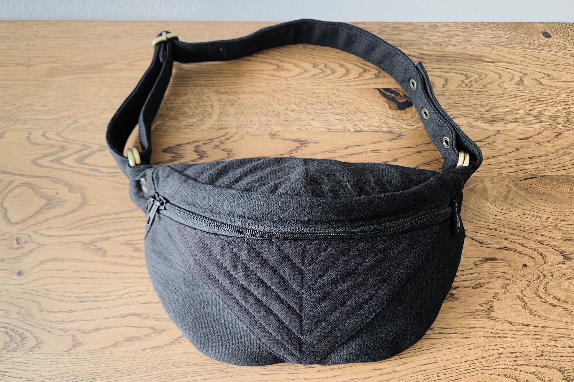 Crossbody-Tasche aus Baumwolle mit Nahtstruktur in schwarz, Gesamtansicht liegend, kleine Größenvariante XS-S-M zum Schließen mit Druckknöpfen.