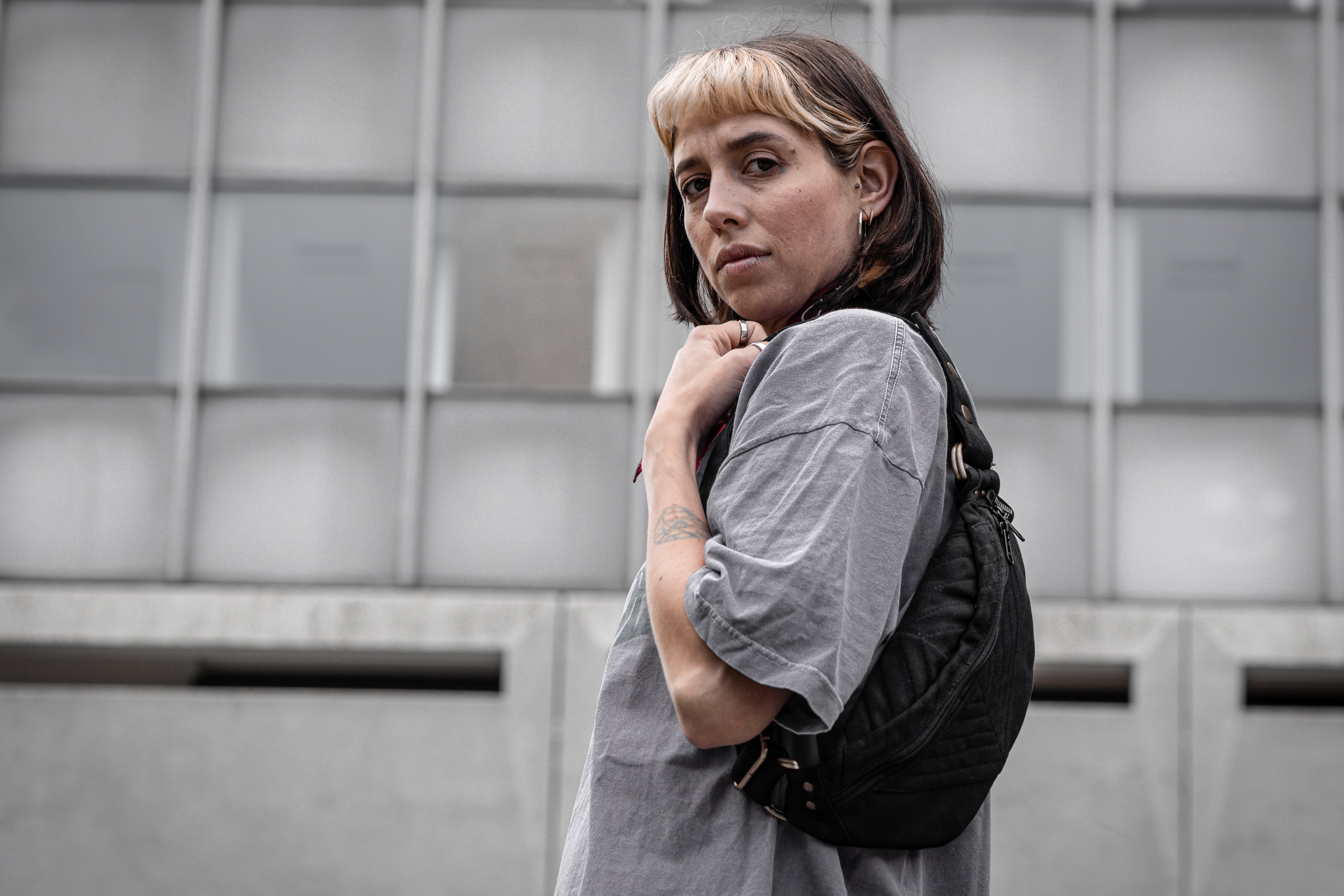 Crossbody-Tasche aus fester Baumwolle mit Nahtstruktur in schwarz, getragen als Shoulder Bag an alternativem Model.