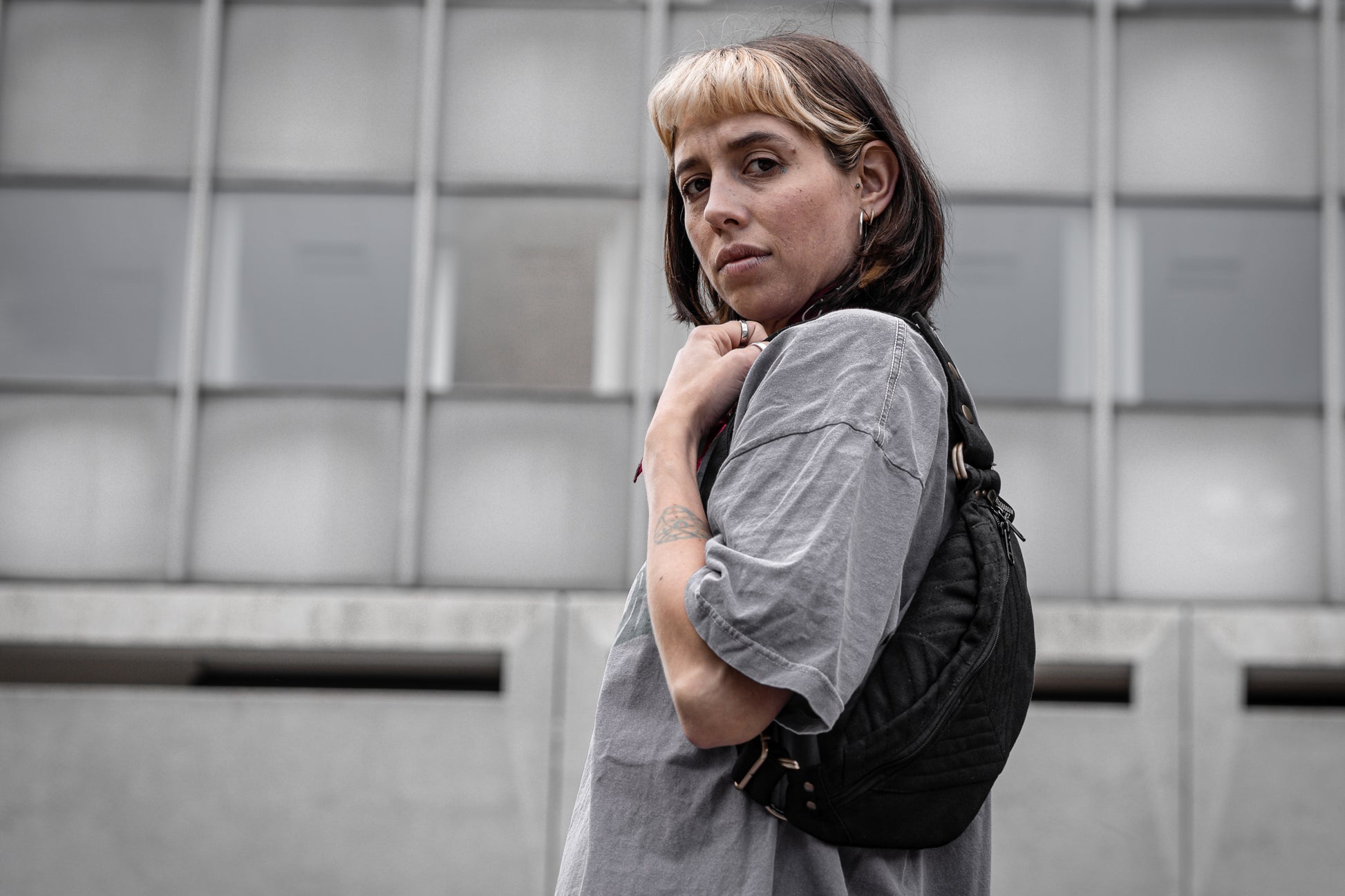 Crossbody-Tasche aus fester Baumwolle mit Nahtstruktur in schwarz, getragen als Shoulder Bag an alternativem Model.