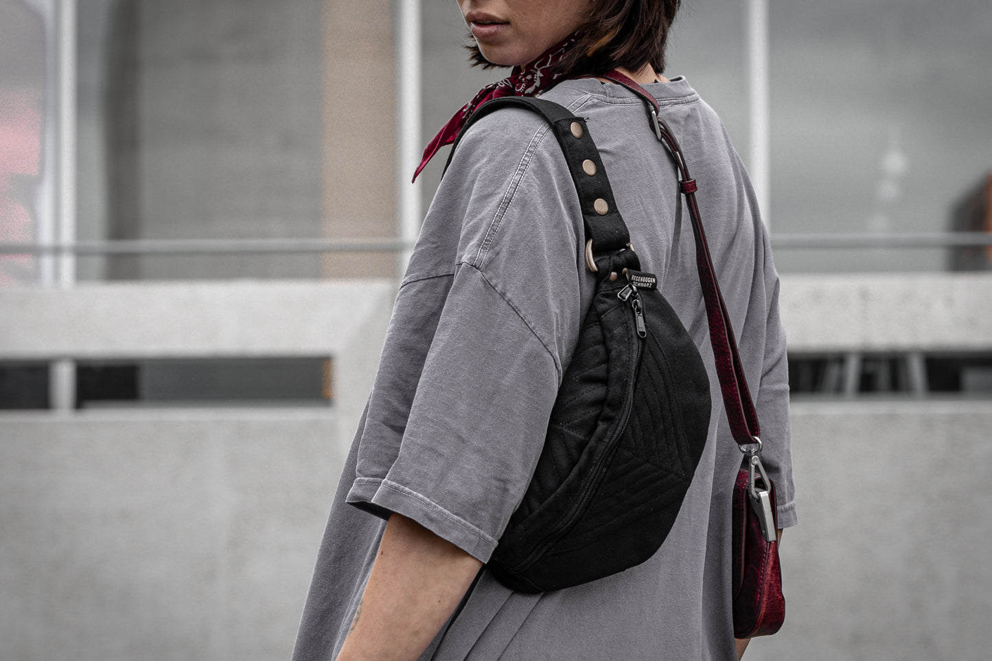 Crossbody-Tasche aus Baumwolle mit geometrischer Nahtstruktur in schwarz, getragen als Schultertasche.