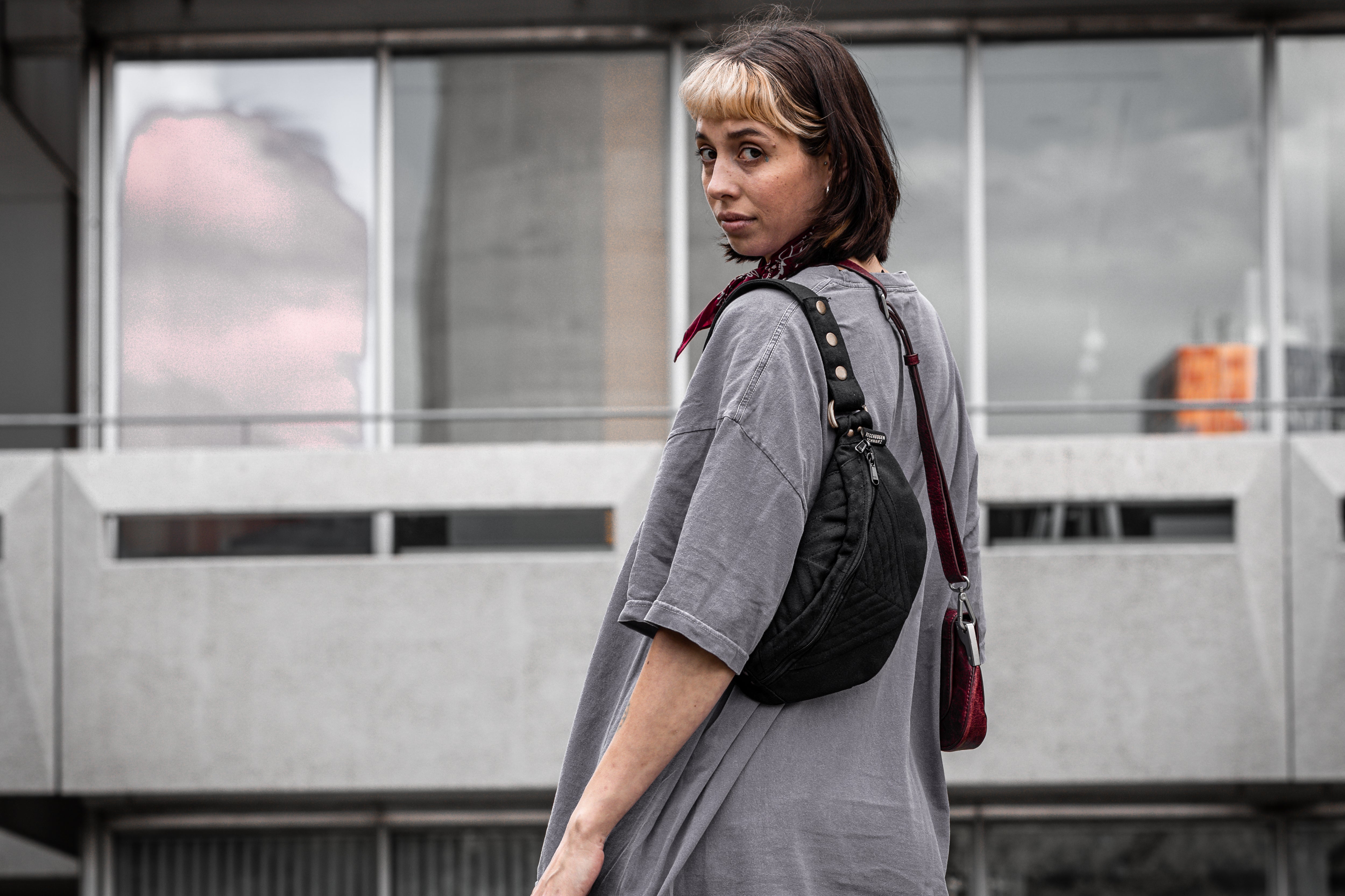 Crossbody-Tasche aus Baumwolle in schwarz, getragen an weiblich gelesenem Model.
