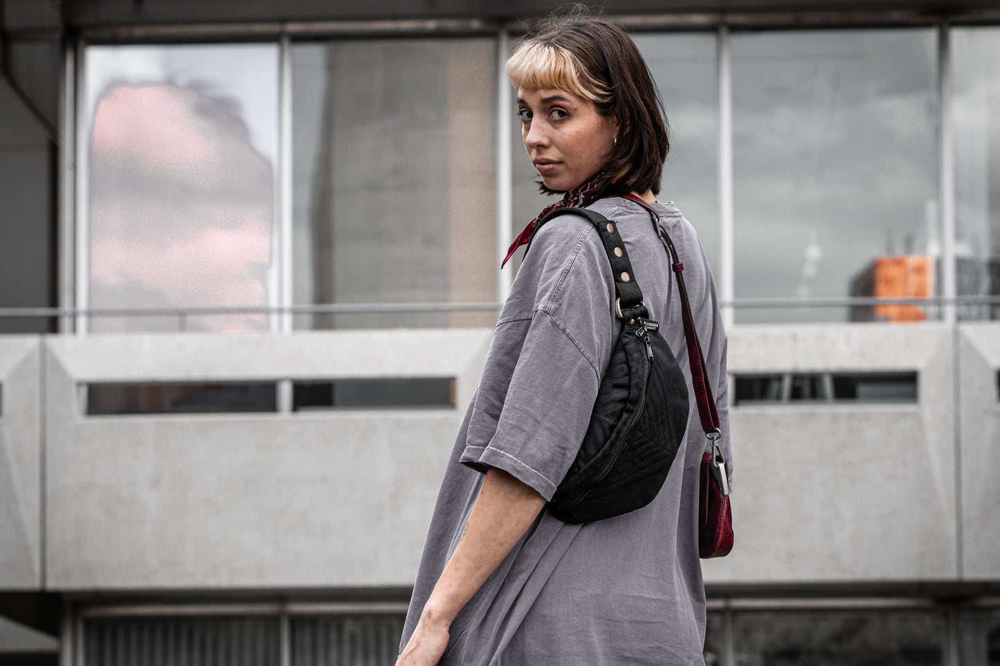 Crossbody-Tasche aus Baumwolle in schwarz, getragen an weiblich gelesenem Model.