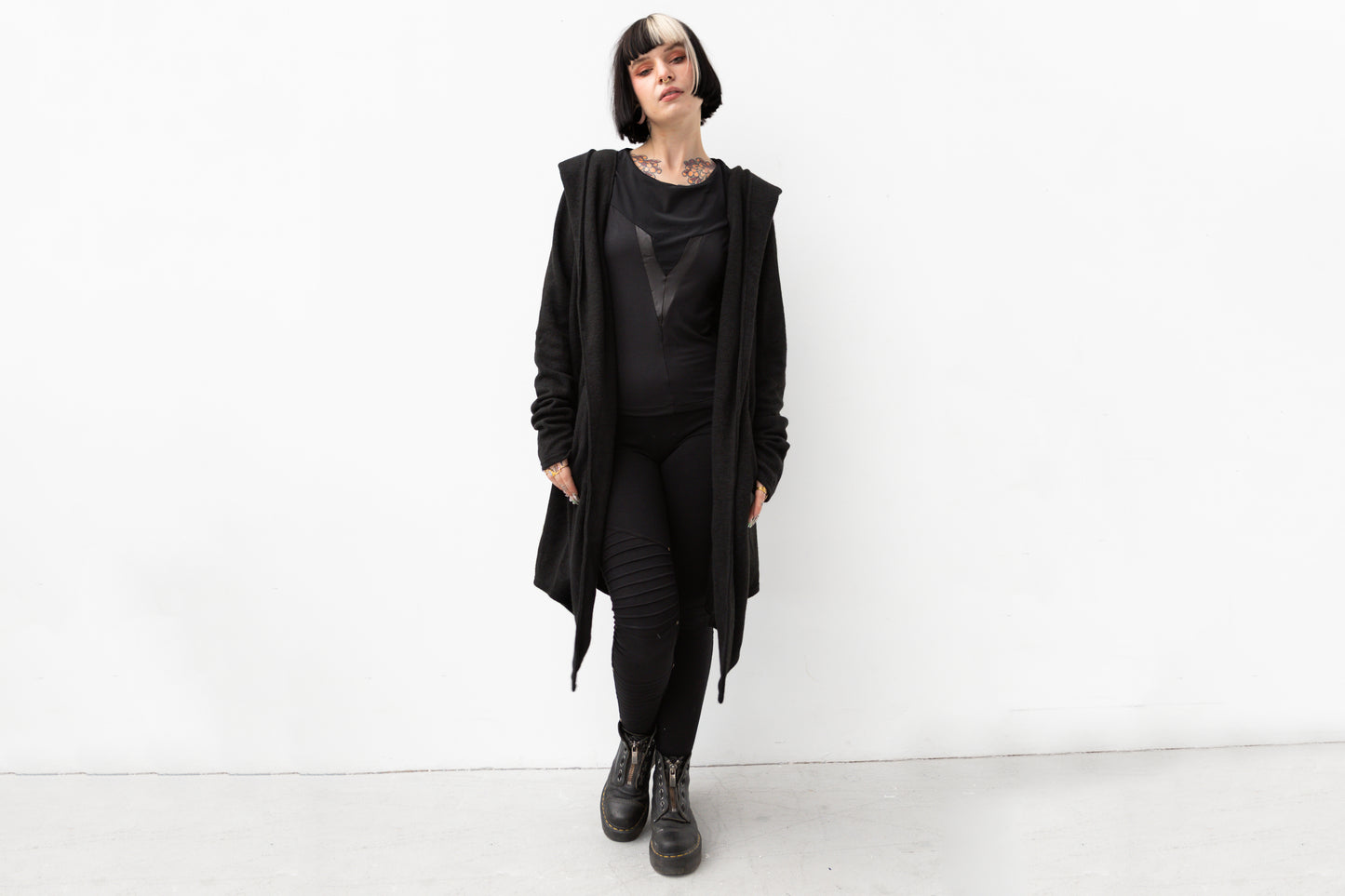 Model trägt schwarzen Kapuzenmantel im Darkwear- und Cyberpunk-Stil, figurumspielender Schnitt, ideal für Herbst und Winter.