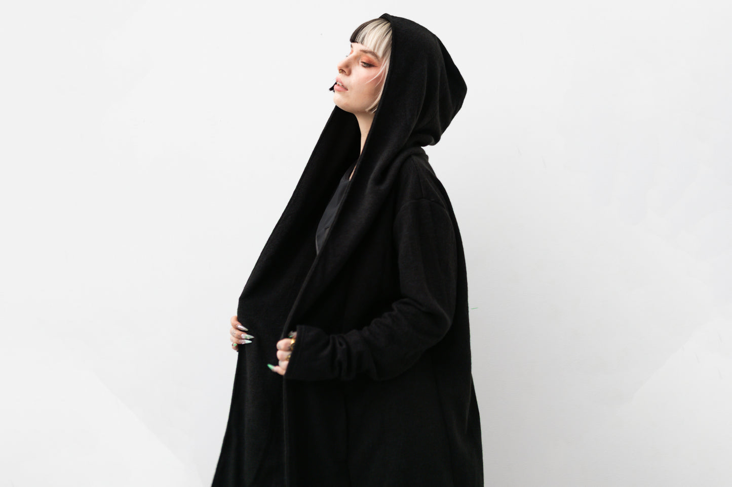 Nahaufnahme von Model, in schwarzem Kapuzenmantel im Darkwear- und Cyberpunk-Stil.