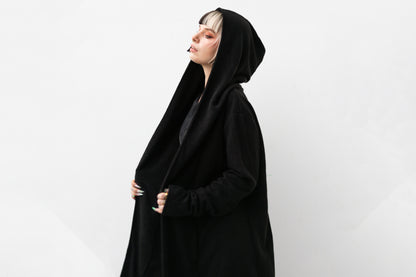 Nahaufnahme von Model, in schwarzem Kapuzenmantel im Darkwear- und Cyberpunk-Stil.