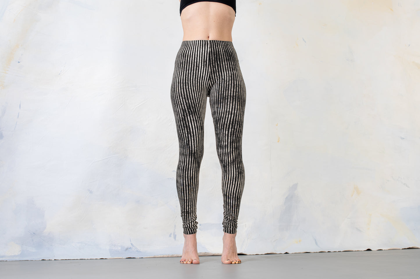 Model trägt schwarz-beige gestreifte Leggings, Aufnahme von vorne.
